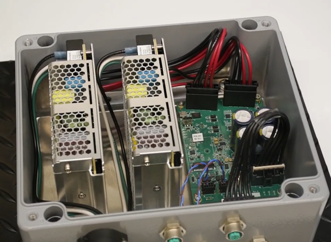 The interior workings of a control panel with exposed circuitboards.