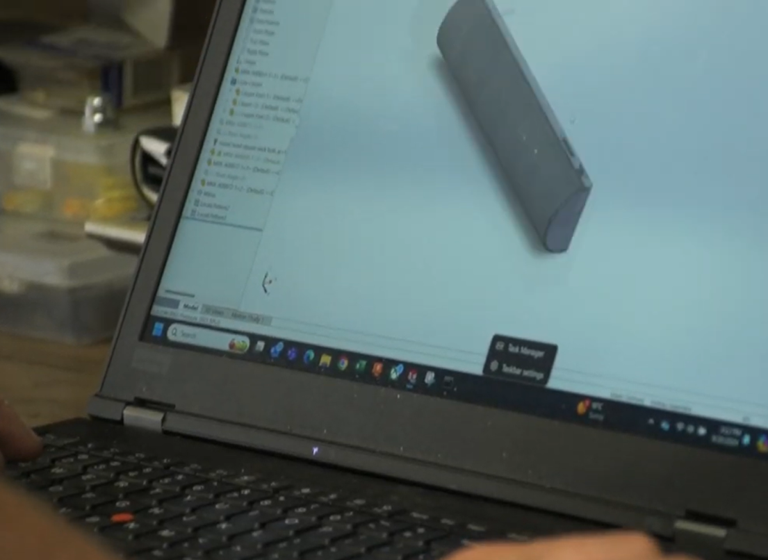 A worker uses the keyboard to control a three-D rendering of a part.