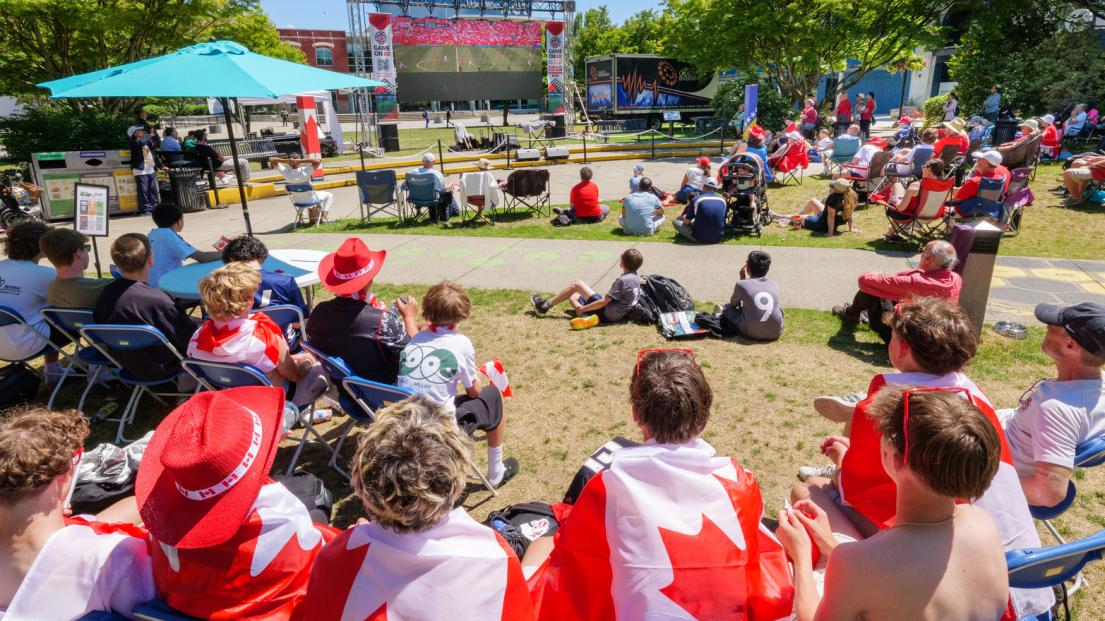 Six boys with a Canada flag on their back apiece watch the 20 foot screen hosting the World Cup with rapt attention.