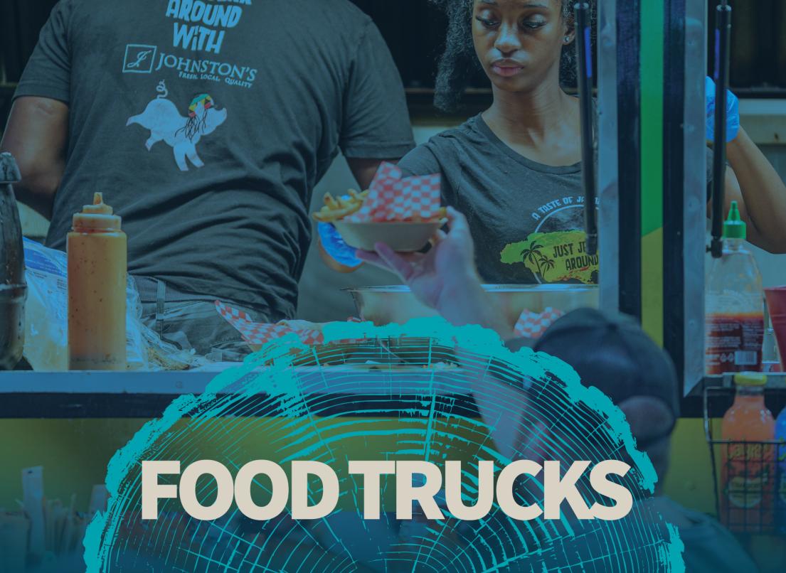 A pair of workers hand a basket of food from the window of a food truck to a customer below.