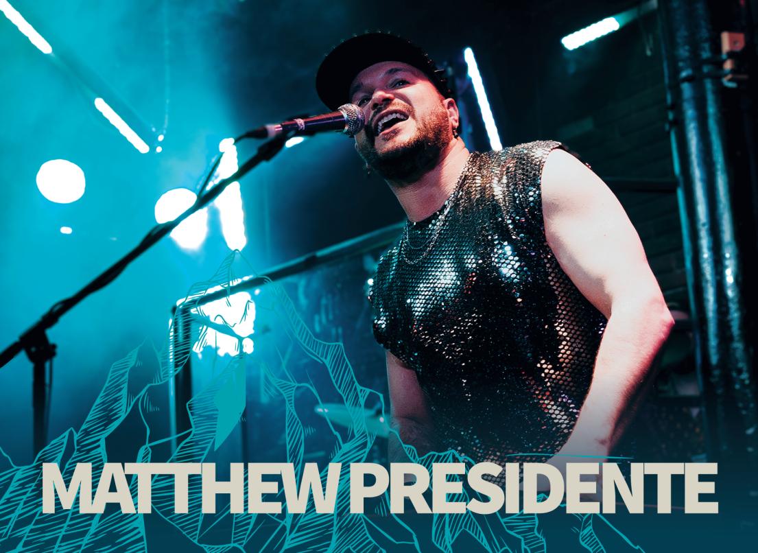 Matthew Presidente sings into a mircophone onstage.