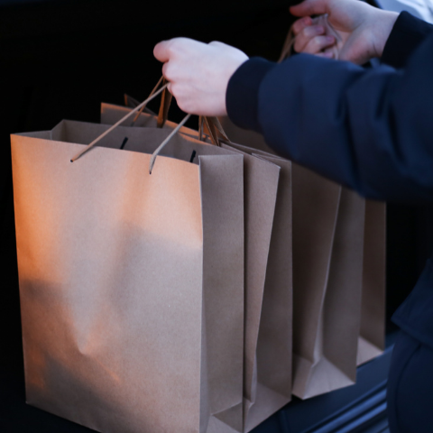 Shop employee stowing customers' bagged purchases for safekeeping