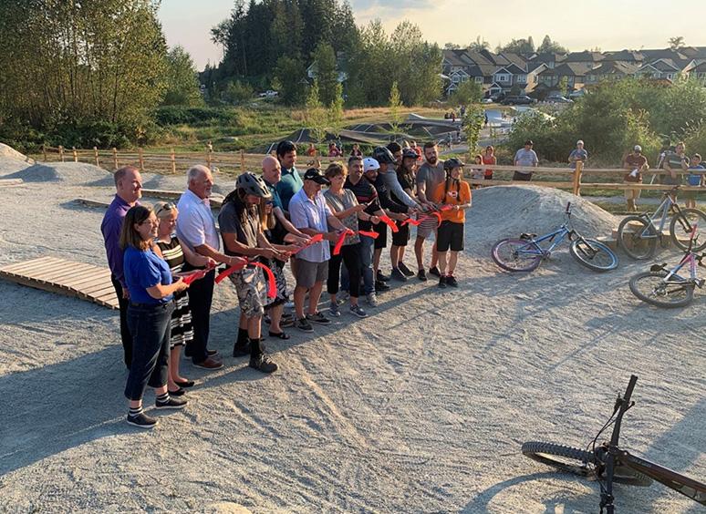 Bikers outside Jordan McIldoon Legacy Bike Skills Park cutting ribbon