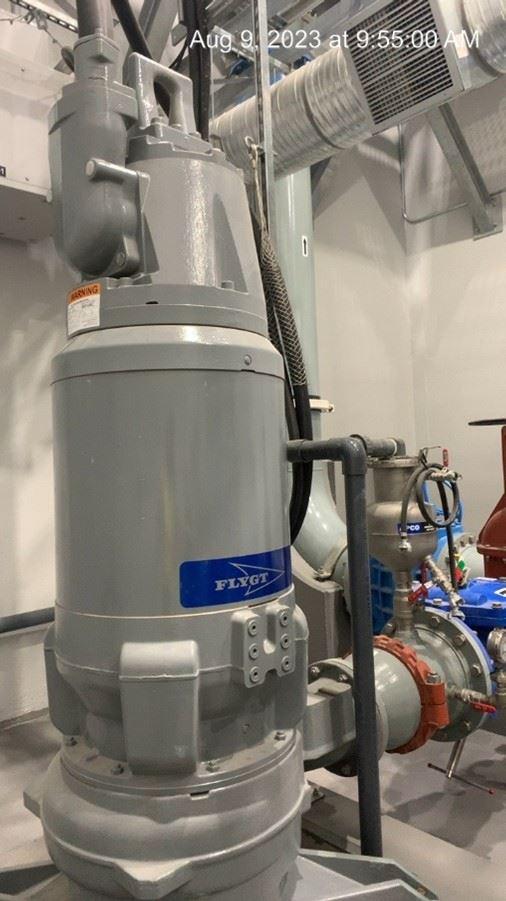 A new grey pump with a large pipe attached to one side.