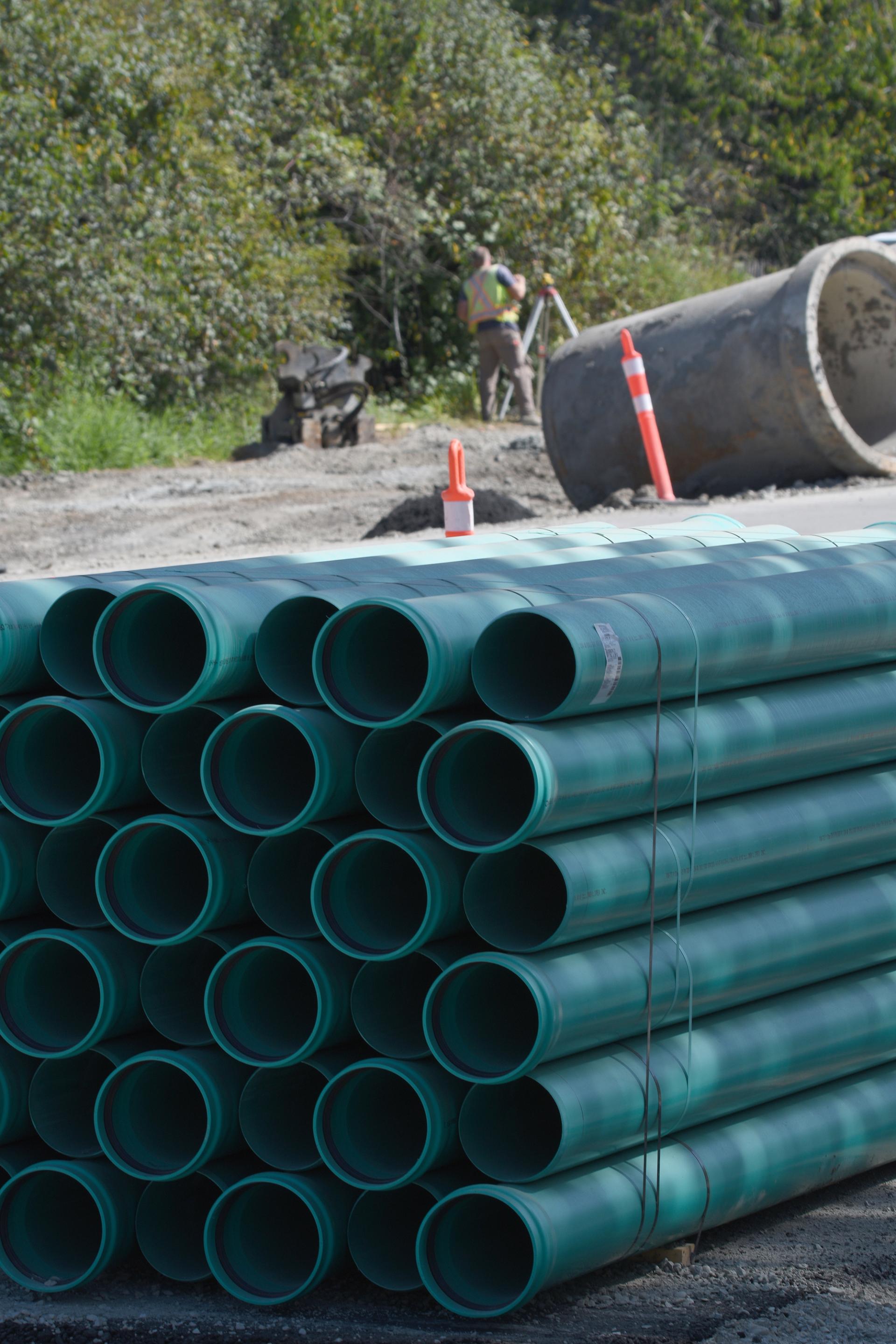 A pile of pipes waiting to be laid in the ground.