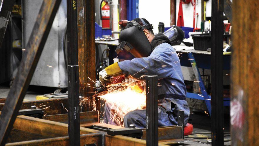 Person arc welding a metal structure inside a workshop