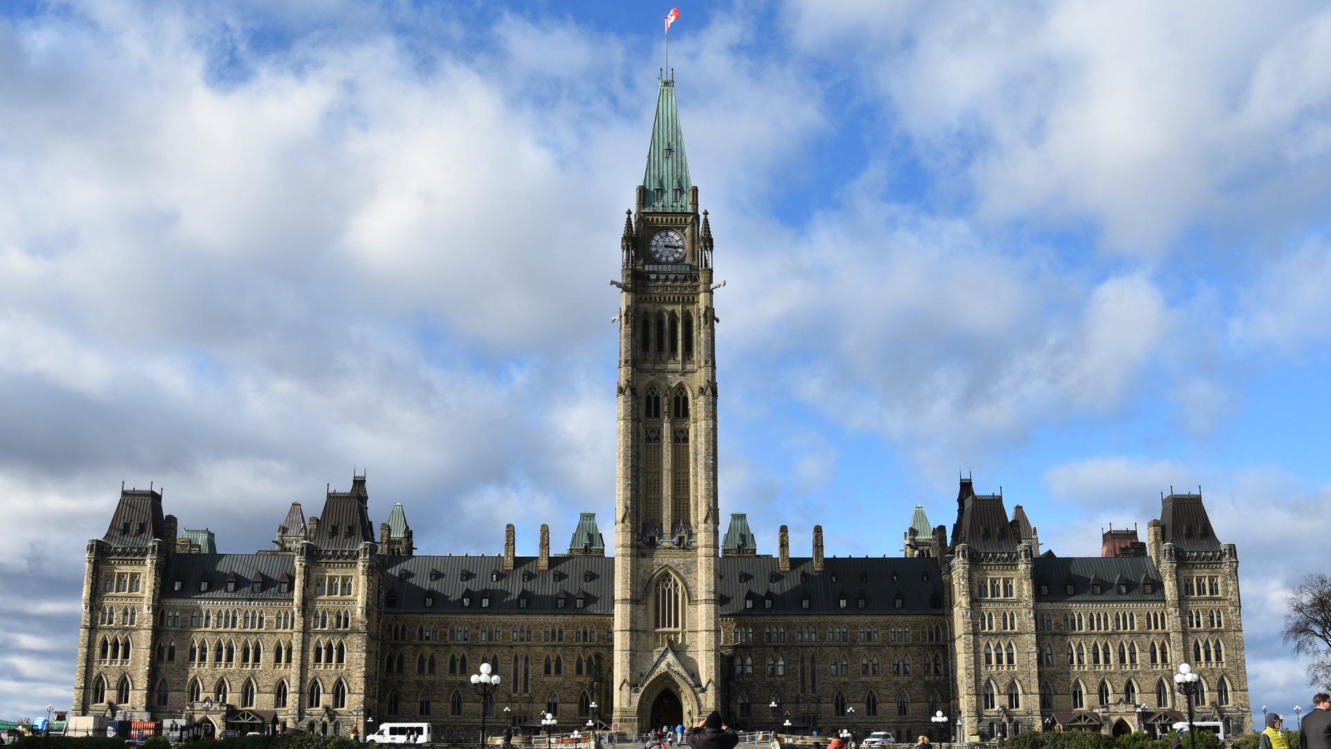 The centre spire of the large green-copper roofed Parliament Building towers above the rest of the structure and onlookers alike.