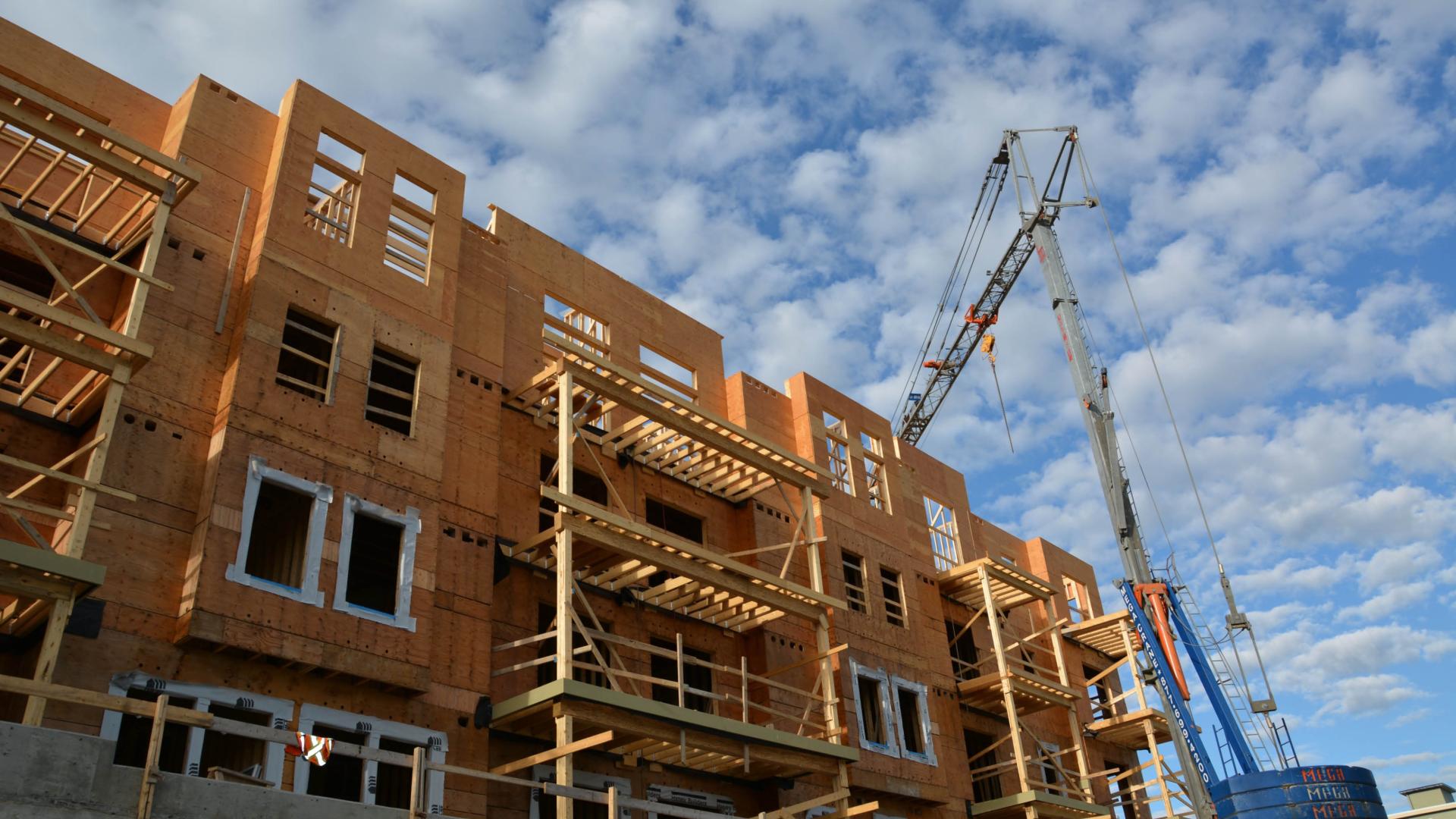An apartment building under construction with exposed woodwork.