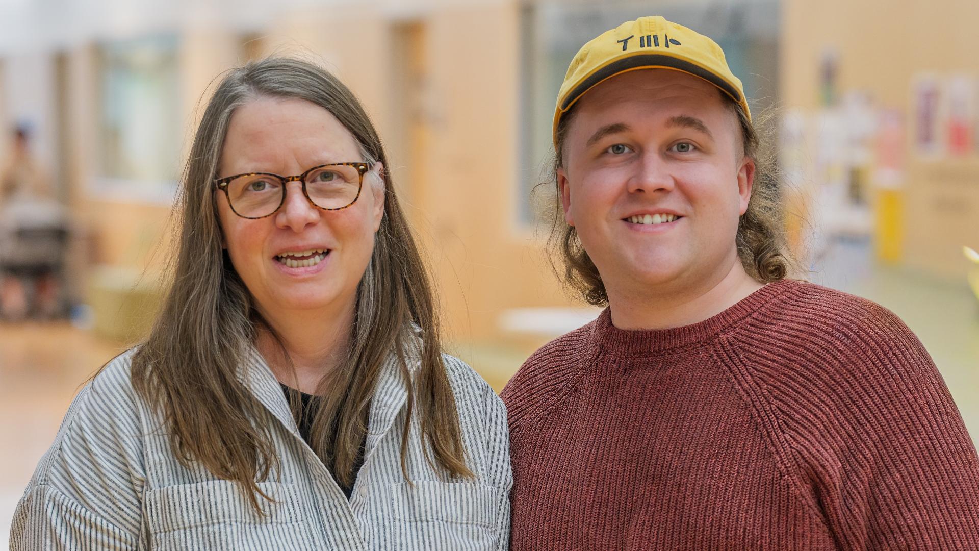 Colleen Brown and Alex Neff stand side by side in the middle of the Albion Community Centre Pop-Up gallery that displays their artworks.