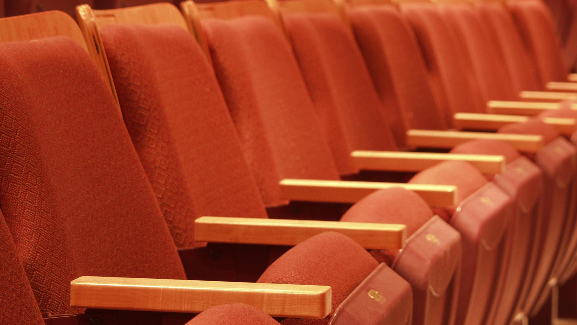 A row of bright red theatre seats facing the ACT Arts Centre's main stage.
