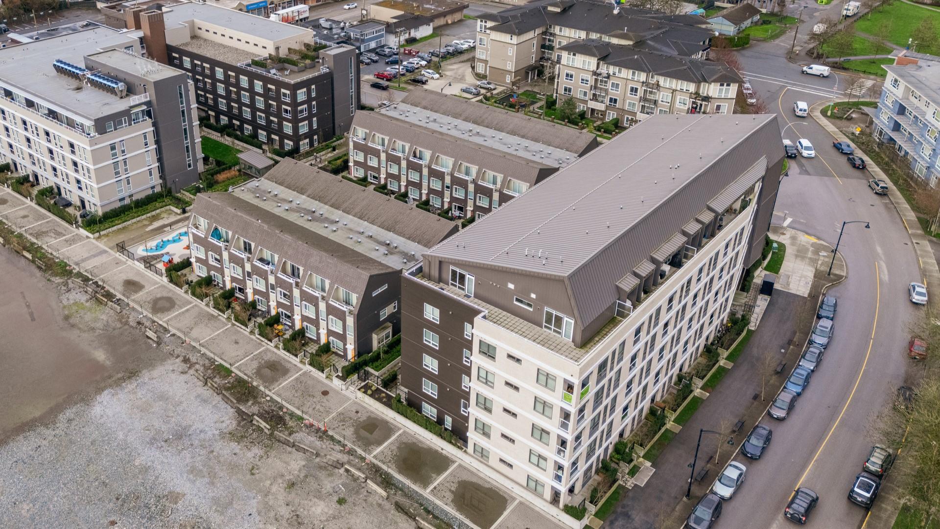 An aerial view of part of the ERA development, a brown-roofed apartment building with white sides.