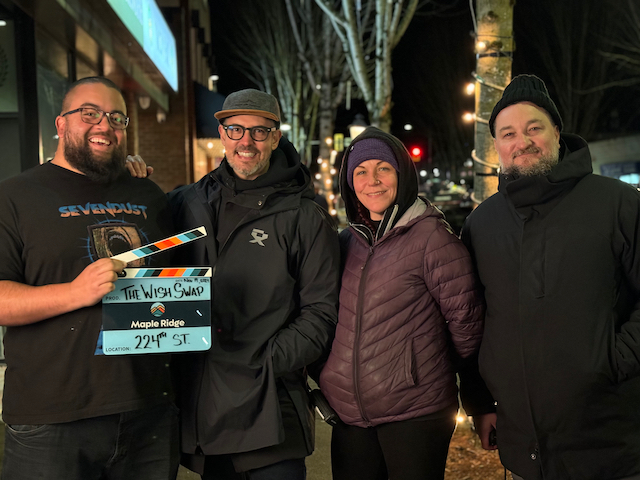 Production members of The Wish Swap holding a City-branded film slate on 224 Street
